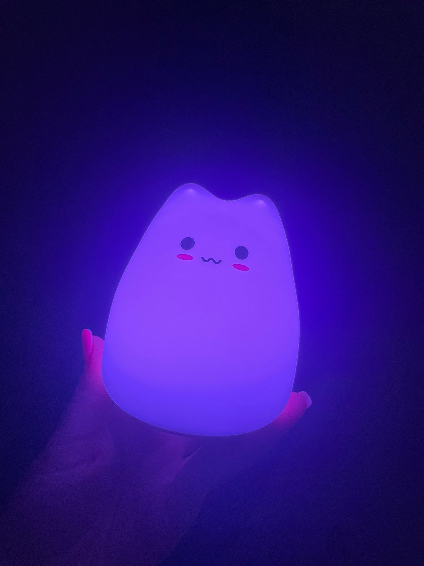 Purple coloured cat lamp is emits a purple light into a dark room
