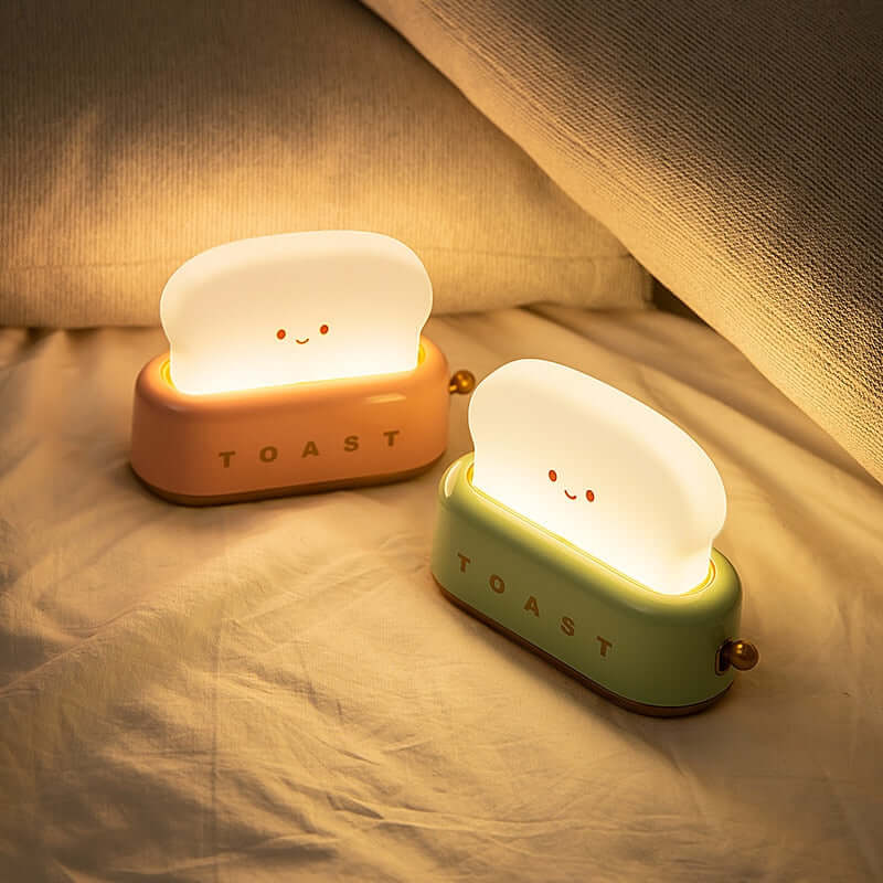 Two toast LED night lights glowing on a bed